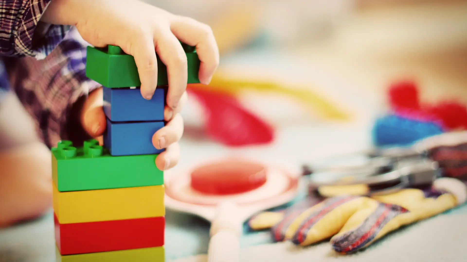 A child playing with toys and building blocks of different colours