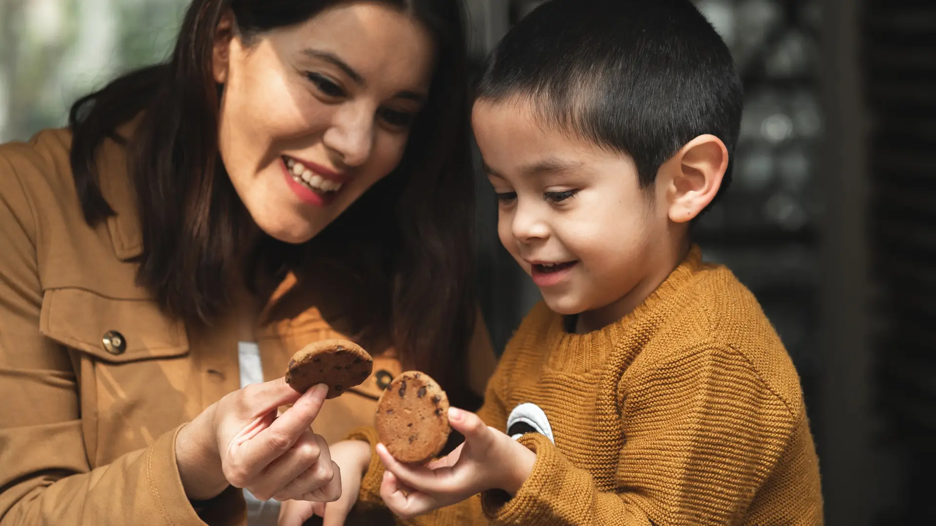 An autistic child and his mom happy and about to eat a cookie