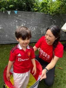 An autistic little boy playing in the garden at school